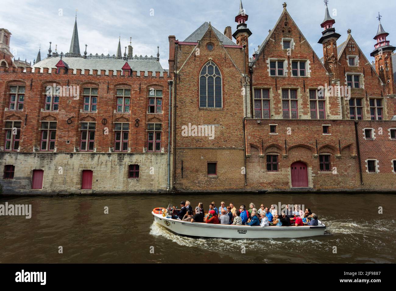 Un bateau avec des touristes navigue sur les canaux de la ville médiévale de Bruges. Belgique. Banque D'Images