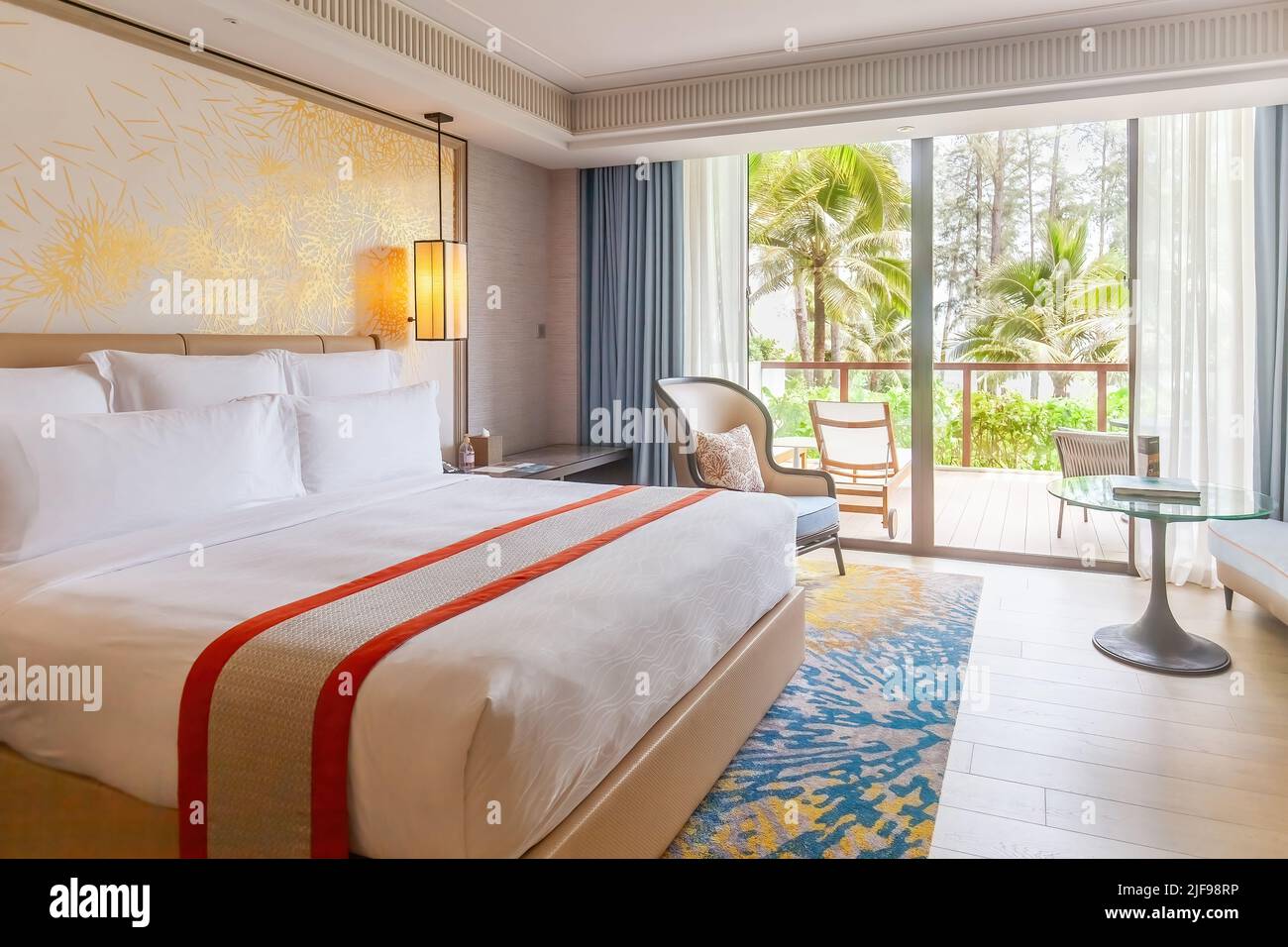 Chambre d'hôtel dans un complexe luxueux et moderne avec vue sur les palmiers tropicaux depuis la fenêtre. Luxueux hôtel de plage pour des vacances d'été. Concept de voyage en Asie Banque D'Images