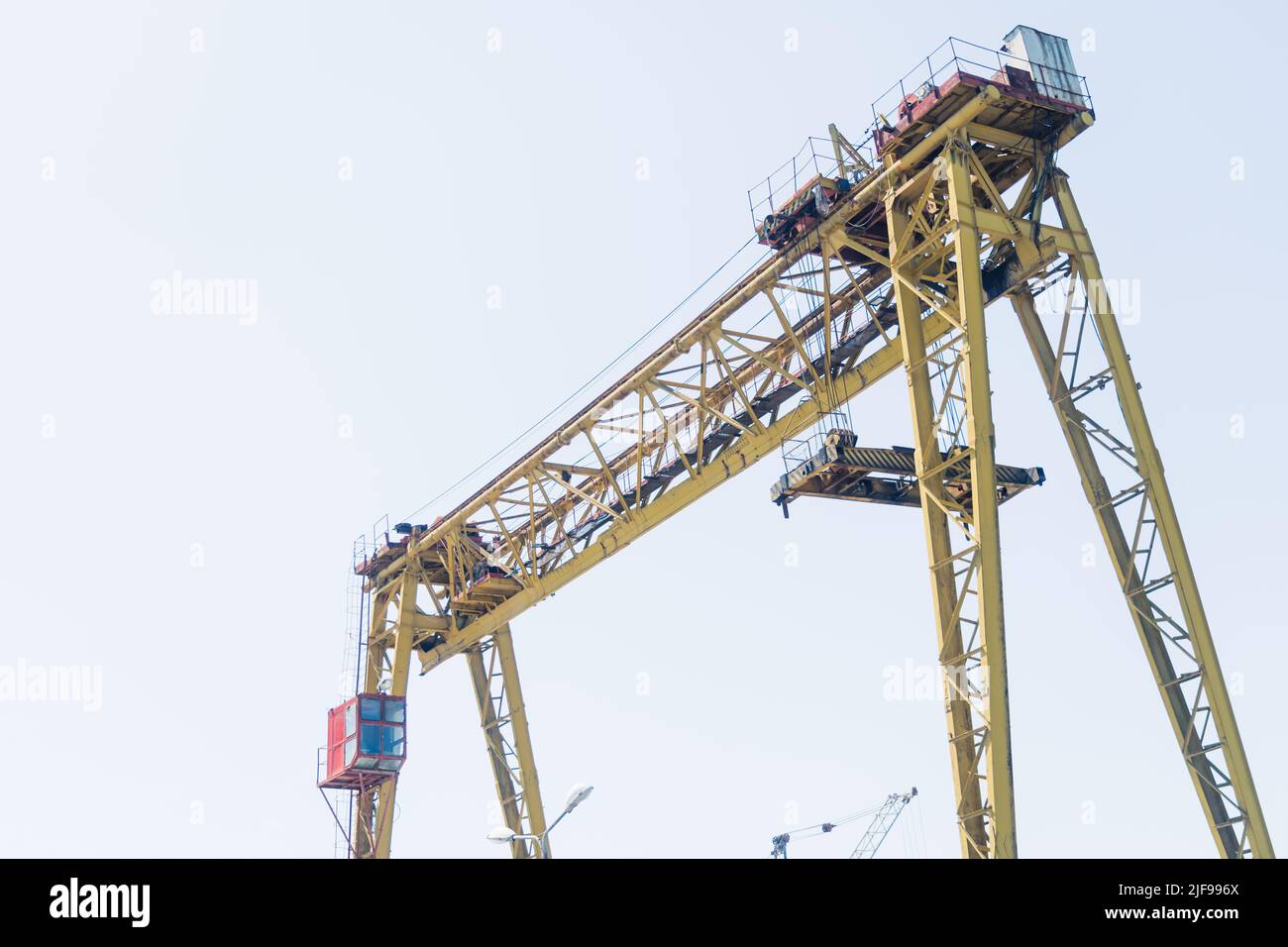 Grue jaune professionnelle sur un chantier de construction. Ciel dégagé. Lieu de travail des cols bleus. Photo de haute qualité Banque D'Images