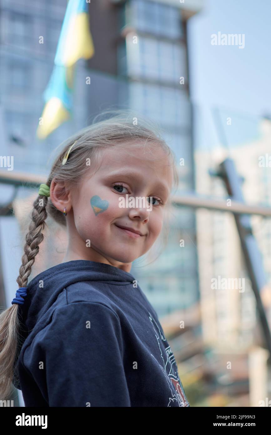 Fille avec drapeau d'Ukraine peint jaune et bleu. Arrêter la guerre et la puissance de l'Ukraine, le patriotisme. Les enfants soutiennent l'Ukraine. Pas de guerre. Priez pour l'Ukraine. Banque D'Images