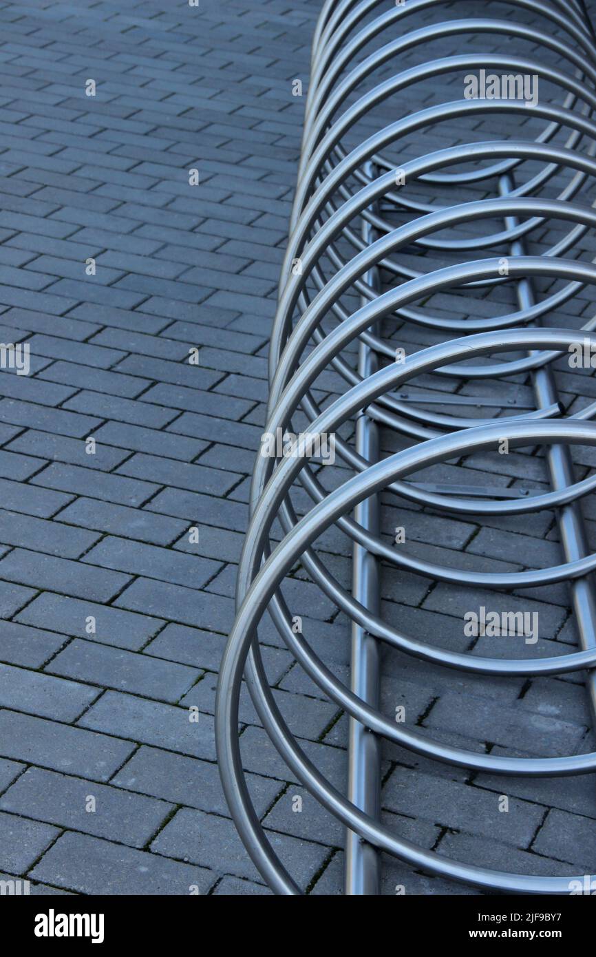 Porte-vélos en acier inoxydable. Le stand de stationnement moderne pour vélos fait un arrière-plan abstrait. Banque D'Images