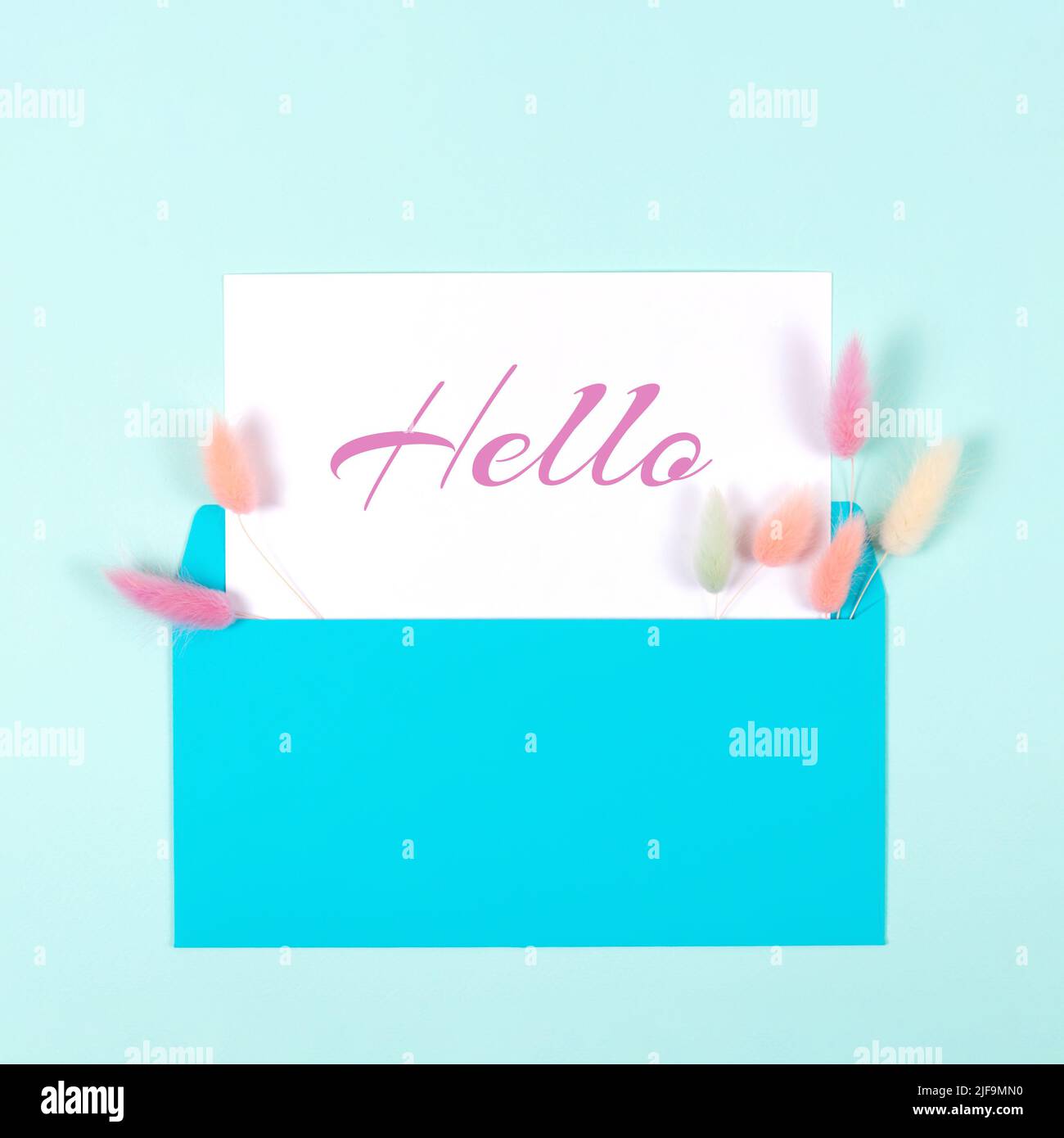 Carte Hello carrée avec enveloppe bleue et œillets colorés sur fond bleu pastel. Style de pose à plat. Concept d'accueil. Banque D'Images