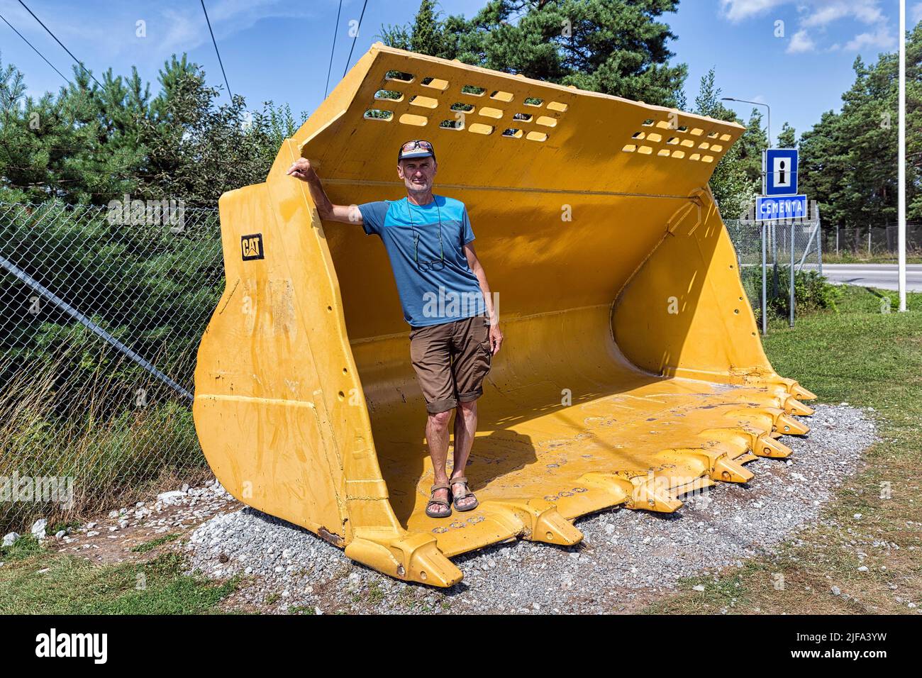 Tourisme debout dans une pelle de chargeuse sur pneus, pelle, Cementa cimenterie, SLite, Gotland Island, Suède Banque D'Images