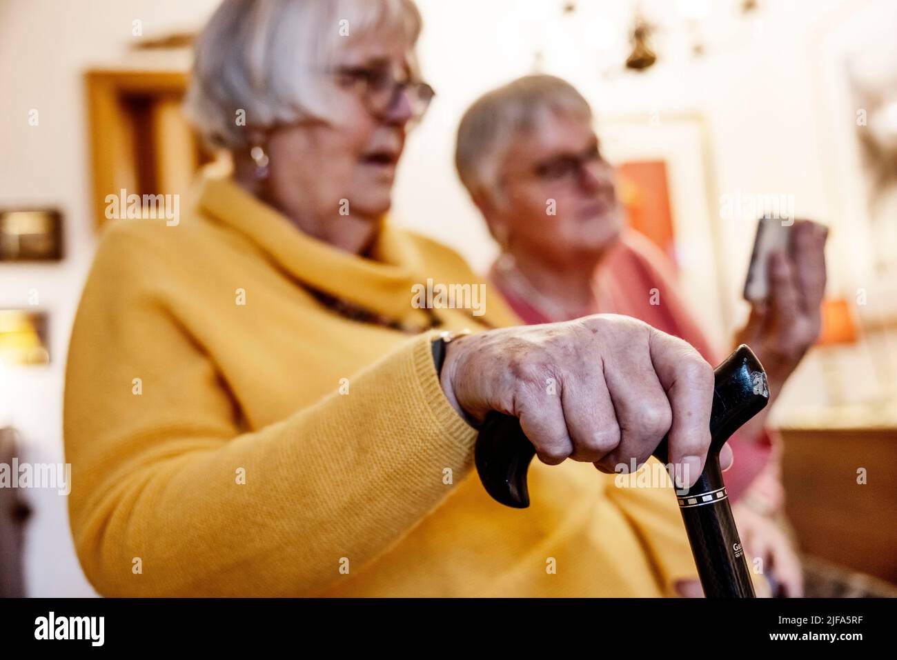 Sa sœur Bocholt, Rhénanie-du-Nord-Westphalie, Allemagne, montre un smartphone à une personne âgée avec béquille Banque D'Images