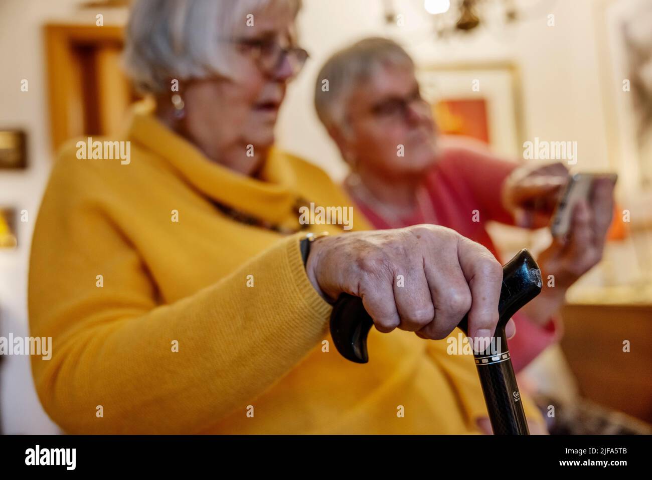 Sa sœur Bocholt, Rhénanie-du-Nord-Westphalie, Allemagne, montre un smartphone à une personne âgée avec béquille Banque D'Images