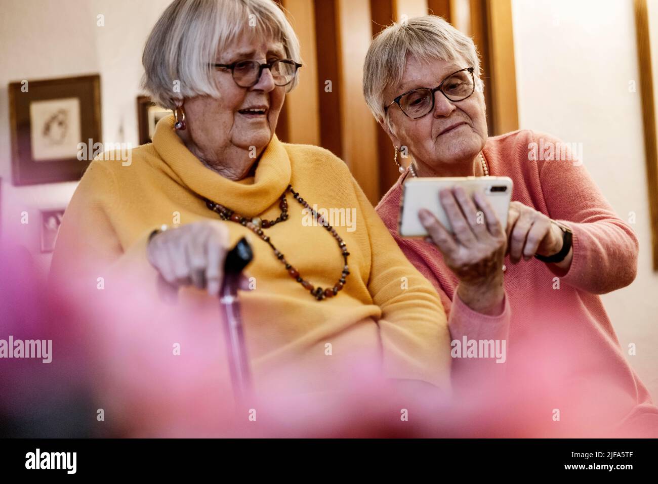 Deux personnes âgées, sœurs, regardant un smartphone à la maison, Bocholt, Rhénanie-du-Nord-Westphalie, Allemagne Banque D'Images