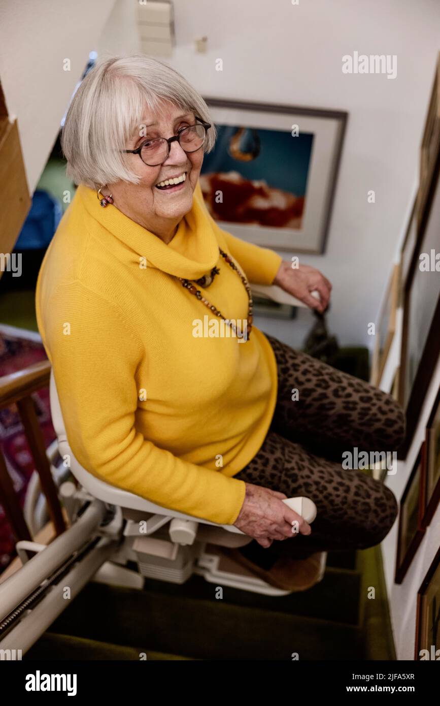 Femme âgée riant à la maison en montant les escaliers, Bocholt, Rhénanie-du-Nord-Westphalie, Allemagne Banque D'Images