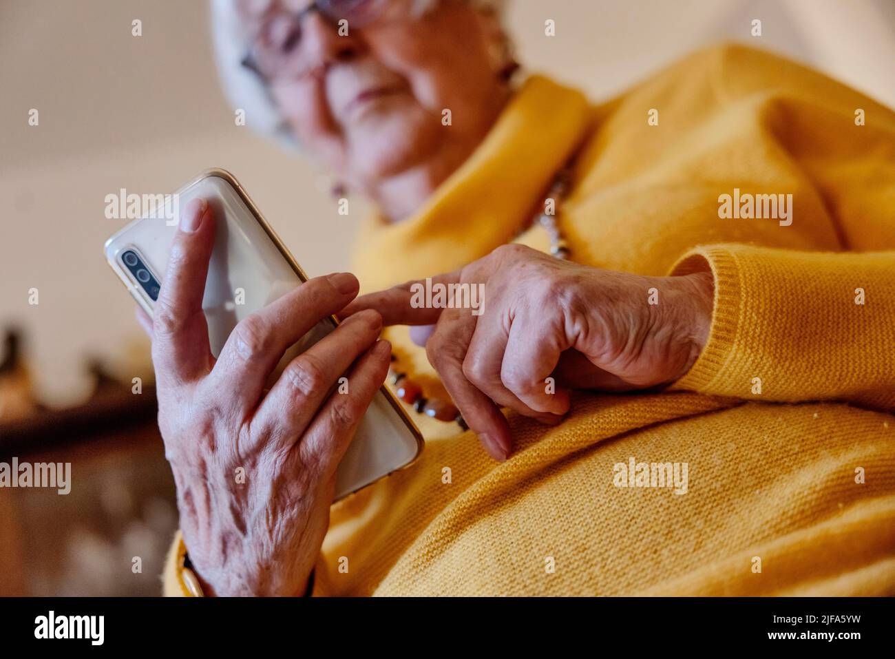 La personne âgée écrit un message sur son smartphone à la maison, Bocholt, Rhénanie-du-Nord-Westphalie, Allemagne Banque D'Images