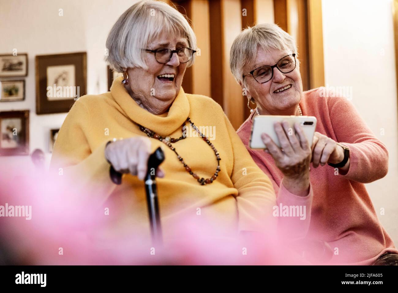 Deux personnes âgées, sœurs, regardant un smartphone à la maison, Bocholt, Rhénanie-du-Nord-Westphalie, Allemagne Banque D'Images