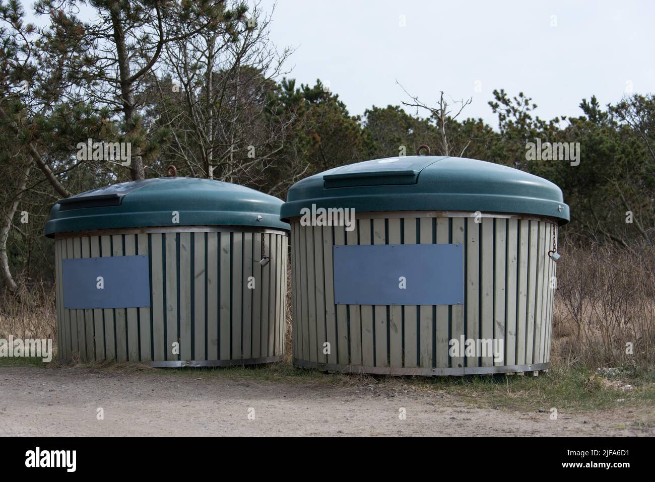 Deux grands conteneurs de recyclage avec des panneaux bleus-gris vides Banque D'Images