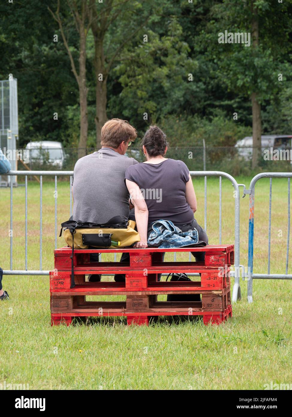 Hulst, pays-Bas, 26 juin 2022, couple assis côte à côte sur des palettes rouges empilées en bois Banque D'Images