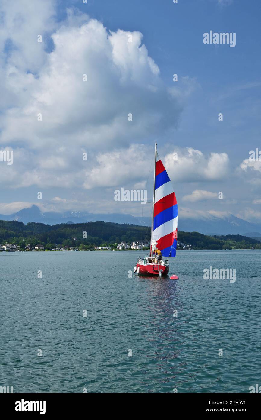 Vue panoramique sur le lac Worth, Autriche avec un bateau à voile, vertical Banque D'Images