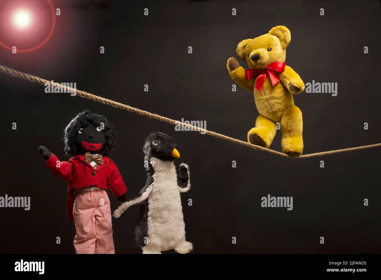 Trois jouets souples ayant du plaisir, avec un ours en peluche marchant une corde serrée Banque D'Images