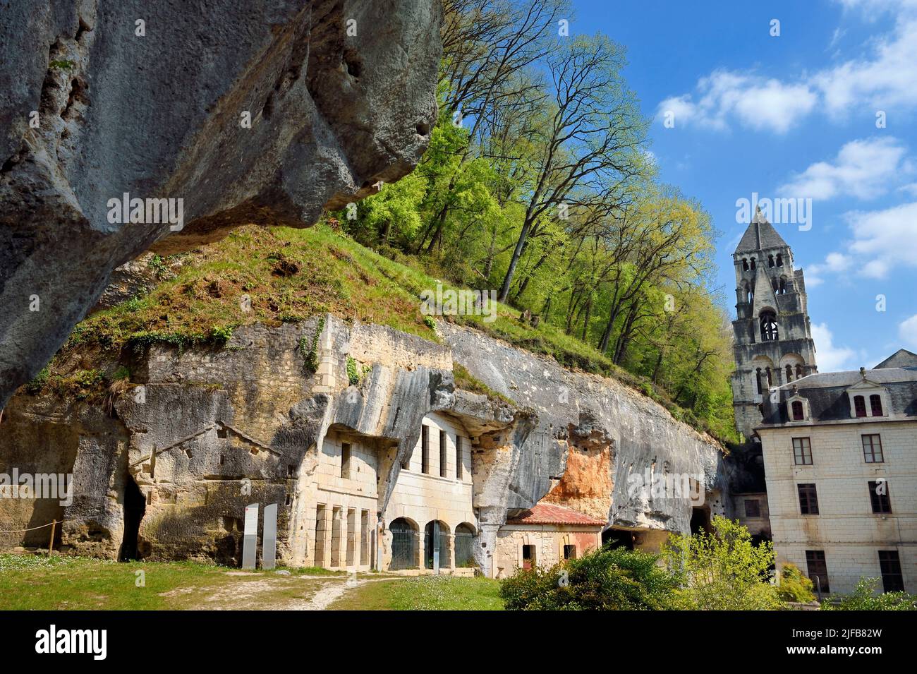 France, Dordogne, Brantôme, abbaye bénédictine Saint-Pierre, les anciennes habitations troglodytes et les grottes nichées dans la falaise et le clocher de l'église abbatiale (11th siècle) en arrière-plan Banque D'Images