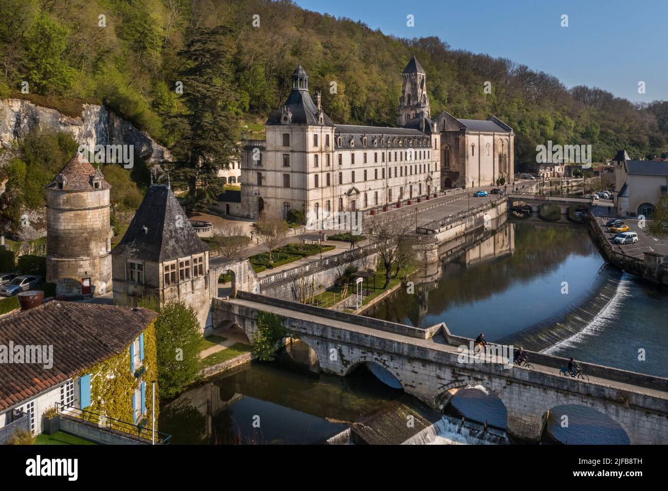 France, Dordogne, Brantôme, cyclistes voyageant le long de la route du vélo de Flow Vélo traversant le Pont Coude (pont incliné) au-dessus de la rivière Dronne, abbaye bénédictine Saint-Pierre en arrière-plan (vue aérienne) Banque D'Images
