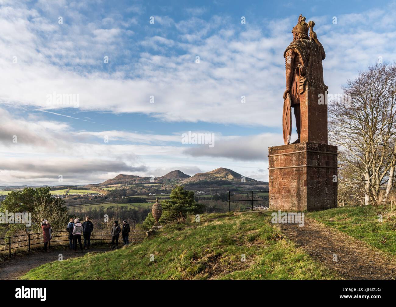Statue de William Wallace ; collines d'Eildon et une grande vue sur la campagne des frontières en arrière-plan ; visite de la partie de bus des touristes en face de la statue. Banque D'Images