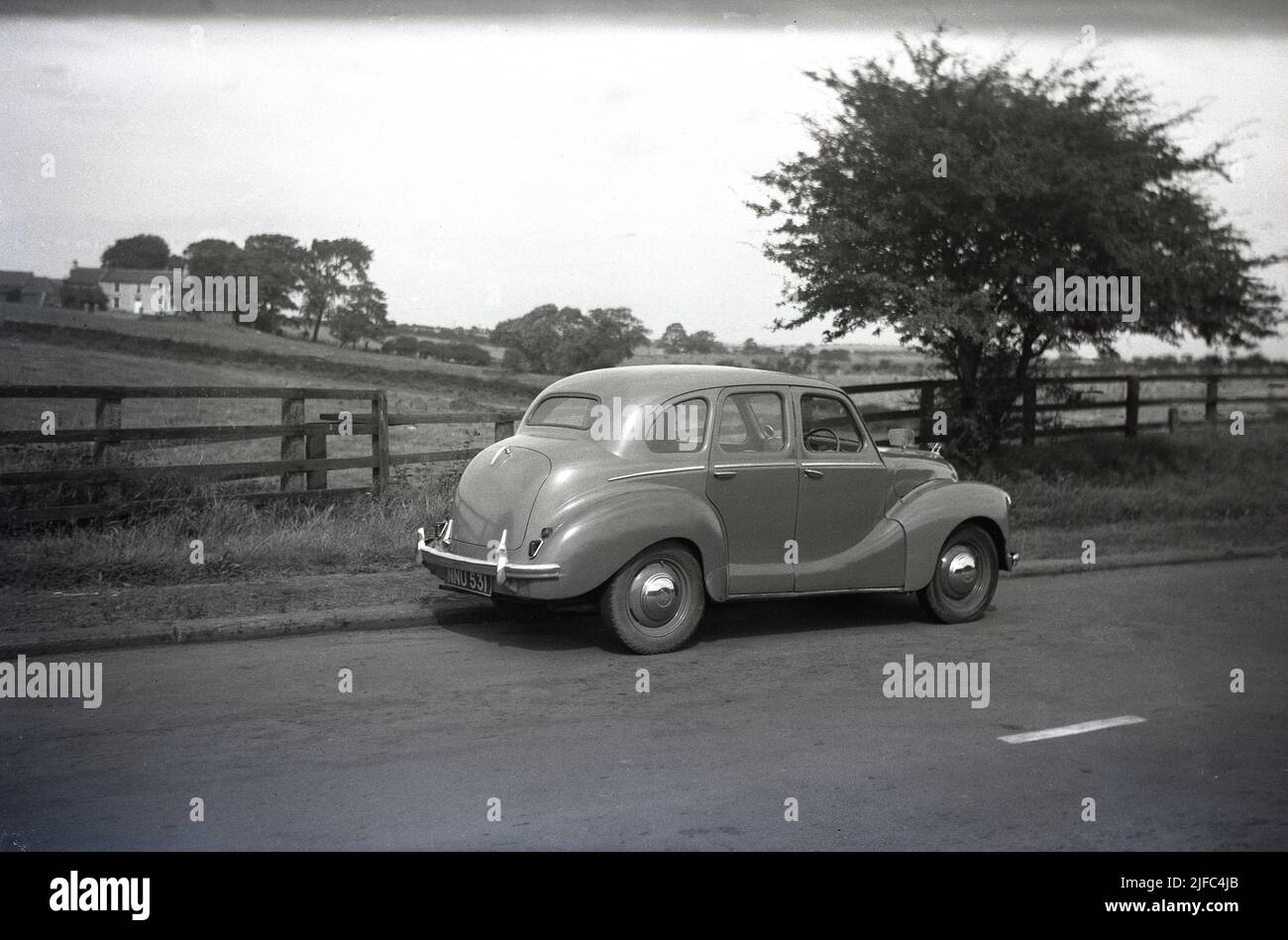 1950s, vue arrière historique d'une voiture Austin de l'époque, une berline Devon A40 garée sur une route de campagne, en Angleterre. Produite entre 1947 et 1952, la voiture a été la première berline d'après-guerre réalisée par la Austin Motor Company. Avec un mélange de technologies anciennes et plus récentes, la voiture a été remarquable pour son style ancien et l'apparence conservatrice. Banque D'Images