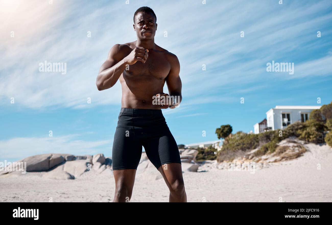 Un jeune athlète afro-américain de sexe masculin s'est bien sorti sur la plage. Boxe noire dédiée tout en s'exerçant à l'extérieur sur le sable Banque D'Images