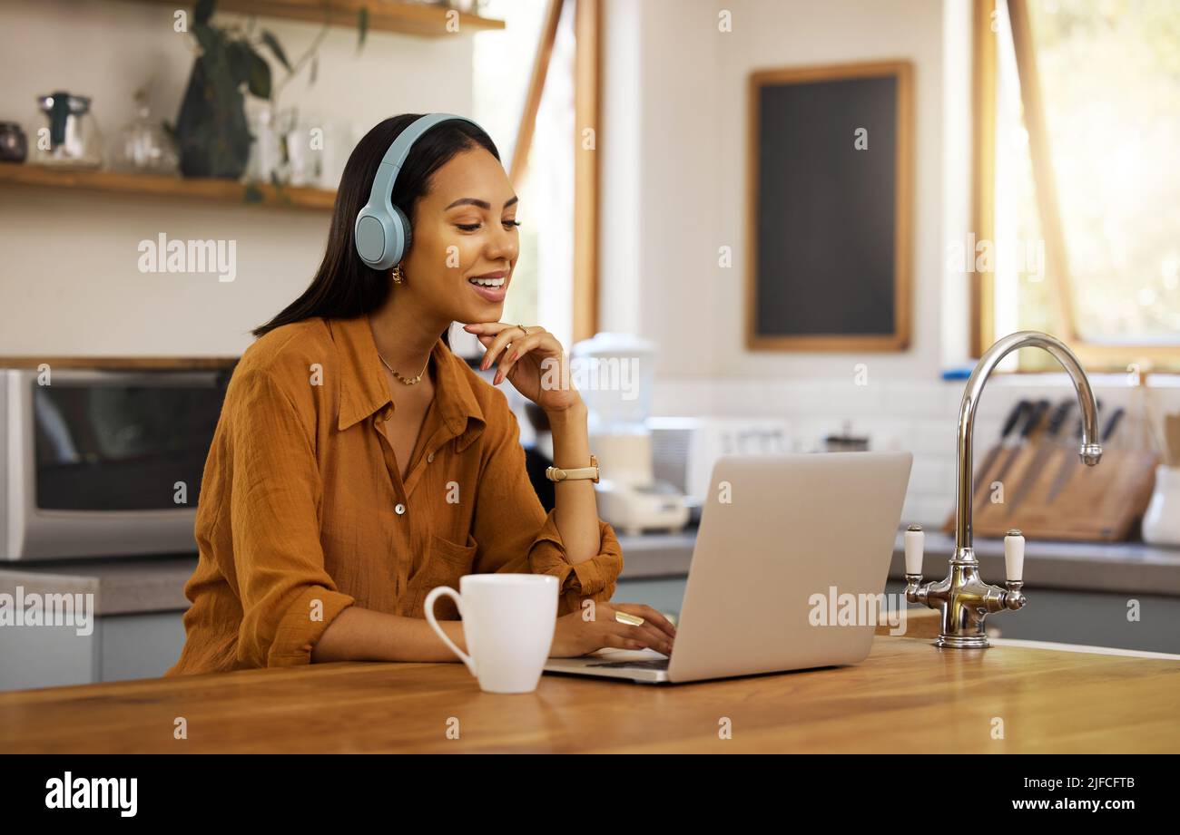 Jeune femme d'affaires heureuse de race mixte parlant lors d'une réunion virtuelle à l'aide d'un ordinateur portable à la maison. Une femme d'affaires hispanique qui parle et porte Banque D'Images