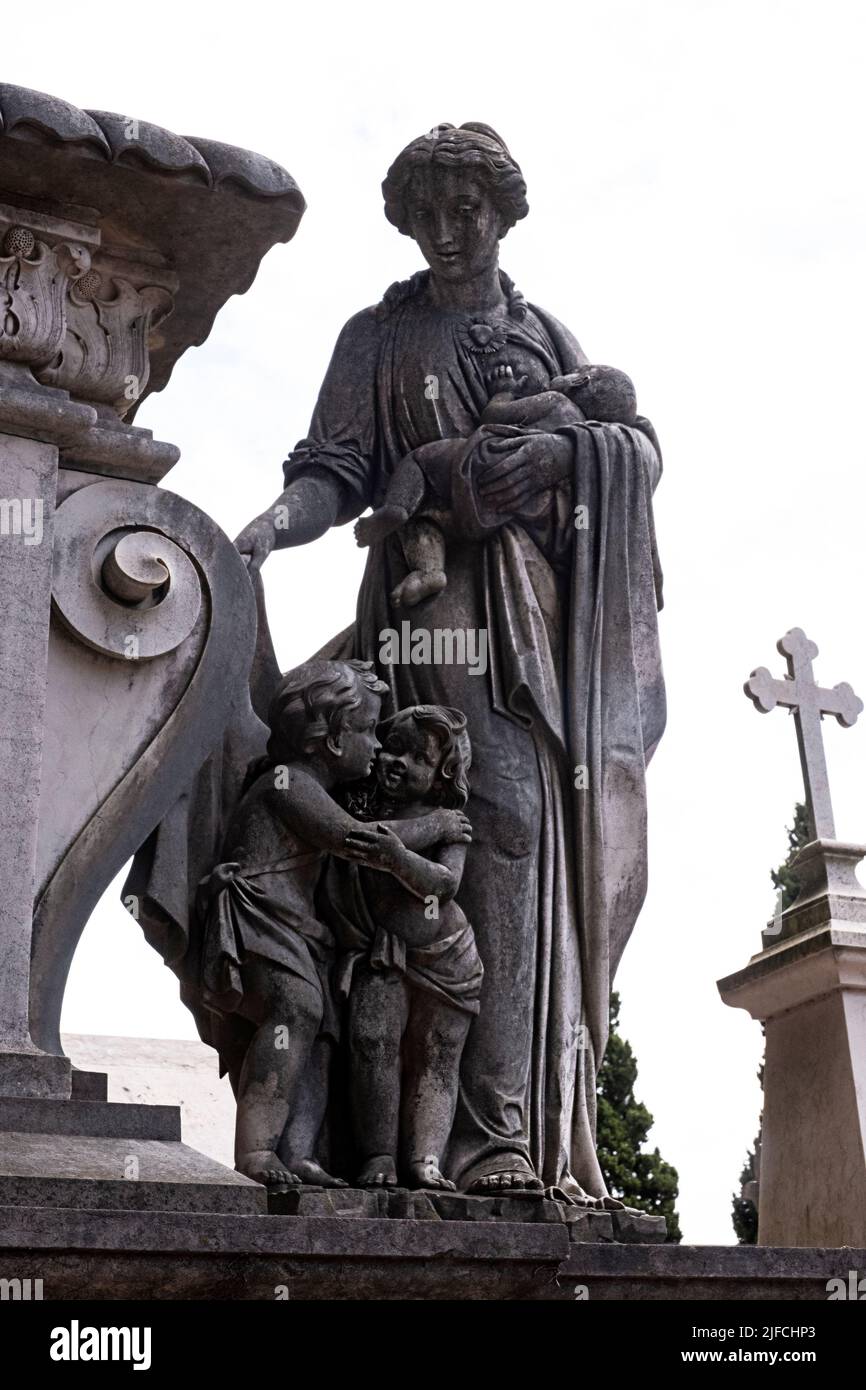 Statue de mère allaitant un enfant au-dessus d'une tombe dans un cimetière de Lisbonne Banque D'Images