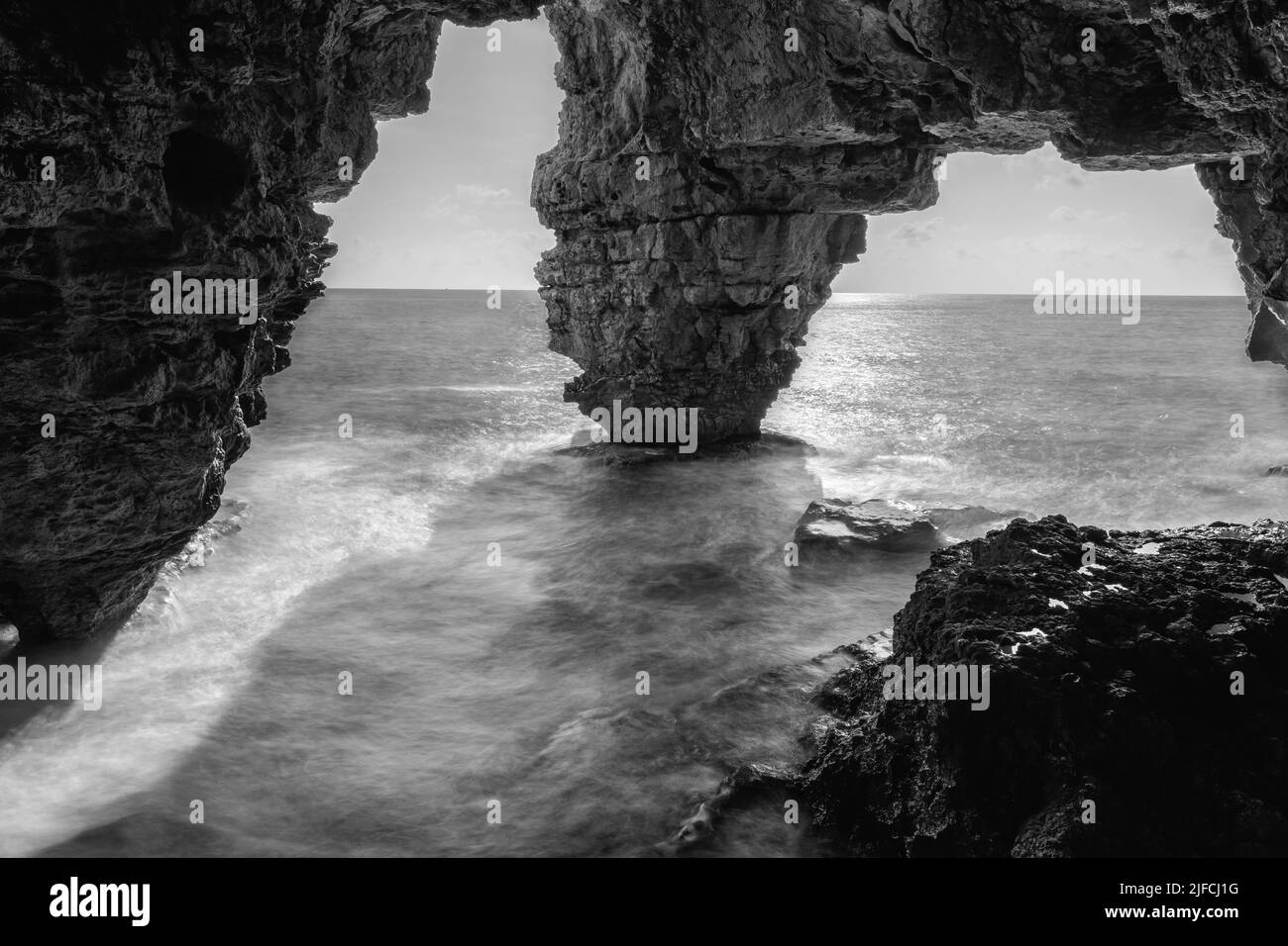 Les ouvertures de la grotte de Moraig à Benitatxell, Alicante, Espagne en niveaux de gris Banque D'Images