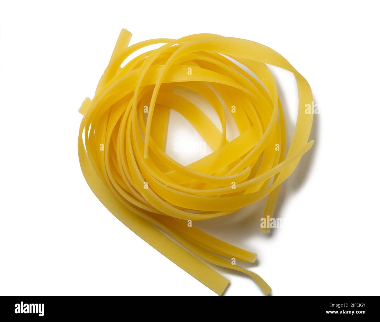 Les pâtes nichent sur un fond blanc. Expérience culinaire. Pâtes cuites sur la table. Produit non cuit. Cuisson. Produit à base de farine et de pâte. Arrière Banque D'Images