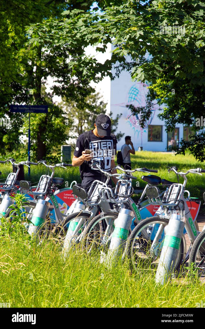 Jeune homme louant un vélo électrique Veturilo à Powiśle, Varsovie, Pologne Banque D'Images