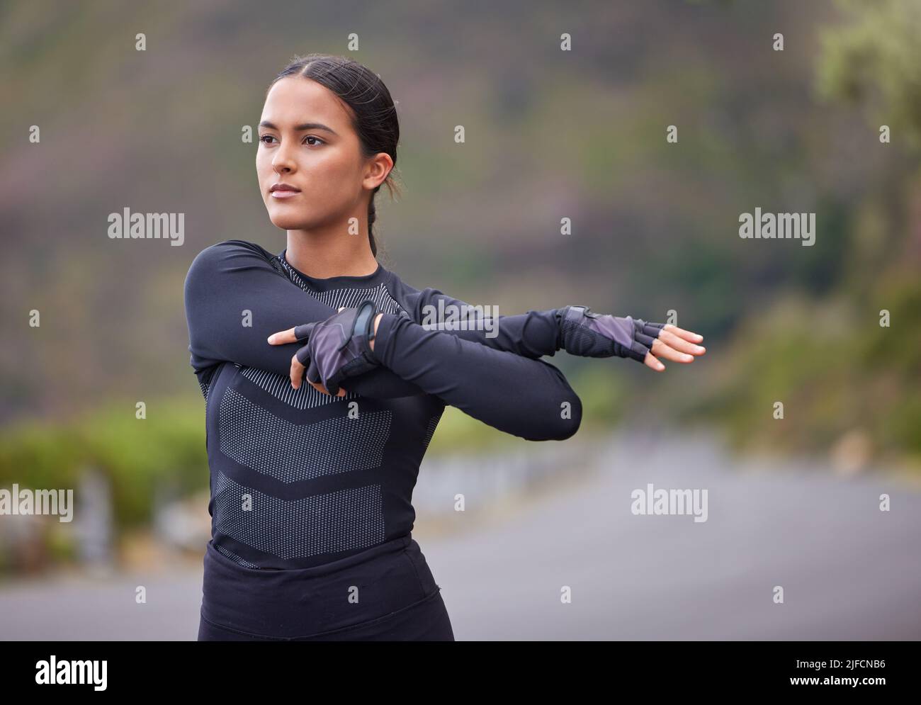Jeune femme hispanique de race mixte s'étirant avant une course à l'extérieur dans la nature. L'exercice est bon pour votre santé et votre bien-être. L'étirement est important pour Banque D'Images