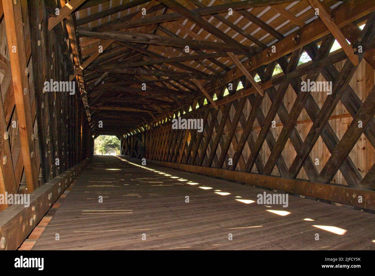 Sous couverture : conception architecturale de l'intérieur du long pont Scott à Townshend, Vermont. Poutres de lumière, d'ombre et de bois. Construit en 1870. Banque D'Images