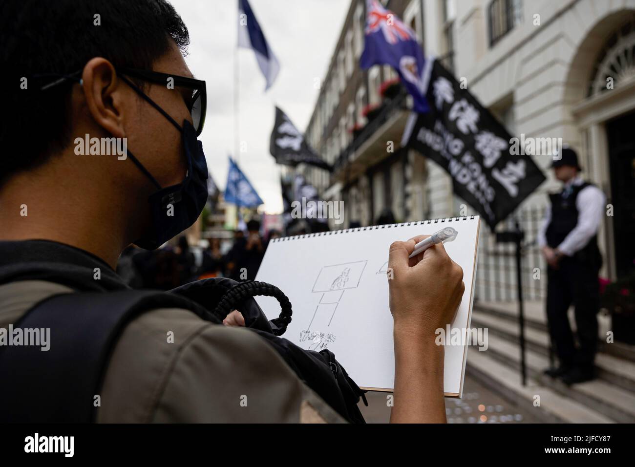 Londres, Royaume-Uni. 01st juillet 2022. Un artiste est vu dessiner lors d'un rassemblement à l'extérieur du Bureau économique et commercial de Hong Kong à Londres. Des centaines de Hongkongais résidant à Londres se sont réunis à l'occasion du 25th anniversaire de la rétrocession de Hong Kong pour protester contre le régime autoritaire du Parti communautaire chinois. Crédit : SOPA Images Limited/Alamy Live News Banque D'Images