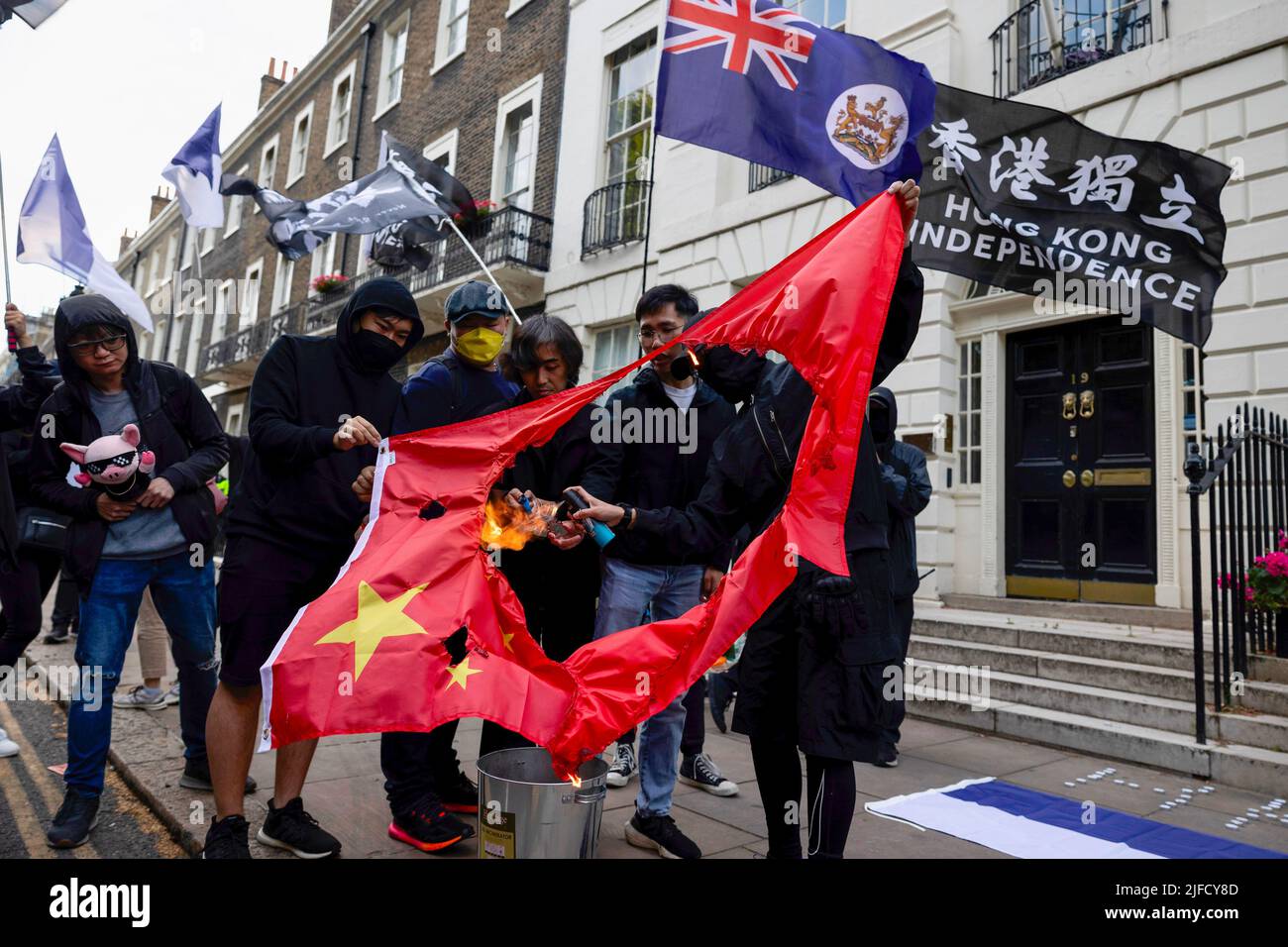 Londres, Royaume-Uni. 01st juillet 2022. Les manifestants sont vus brûler le drapeau chinois lors du rassemblement devant le Bureau économique et commercial de Hong Kong. Des centaines de Hongkongais résidant à Londres se sont réunis à l'occasion du 25th anniversaire de la rétrocession de Hong Kong pour protester contre le régime autoritaire du Parti communautaire chinois. Crédit : SOPA Images Limited/Alamy Live News Banque D'Images