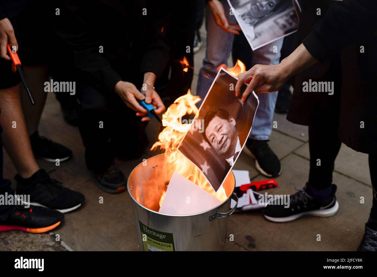 Londres, Royaume-Uni. 01st juillet 2022. Les manifestants brûlent le portrait de Xi Jinping lors du rassemblement devant le Bureau économique et commercial de Hong Kong. Des centaines de Hongkongais résidant à Londres se sont réunis à l'occasion du 25th anniversaire de la rétrocession de Hong Kong pour protester contre le régime autoritaire du Parti communautaire chinois. Crédit : SOPA Images Limited/Alamy Live News Banque D'Images