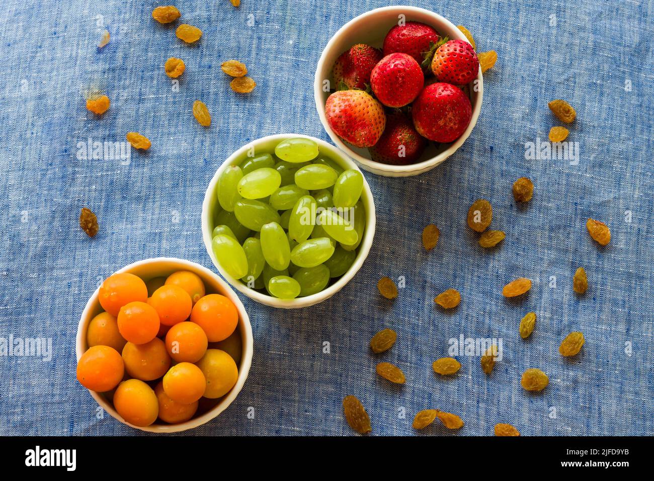 Bol à fruits avec assortiment de groseilles à maquereau, de raisins et de fraises frais et juteux, isolé sur fond rustique foncé. Concept rétroéclairé, fermé, végétalien Banque D'Images