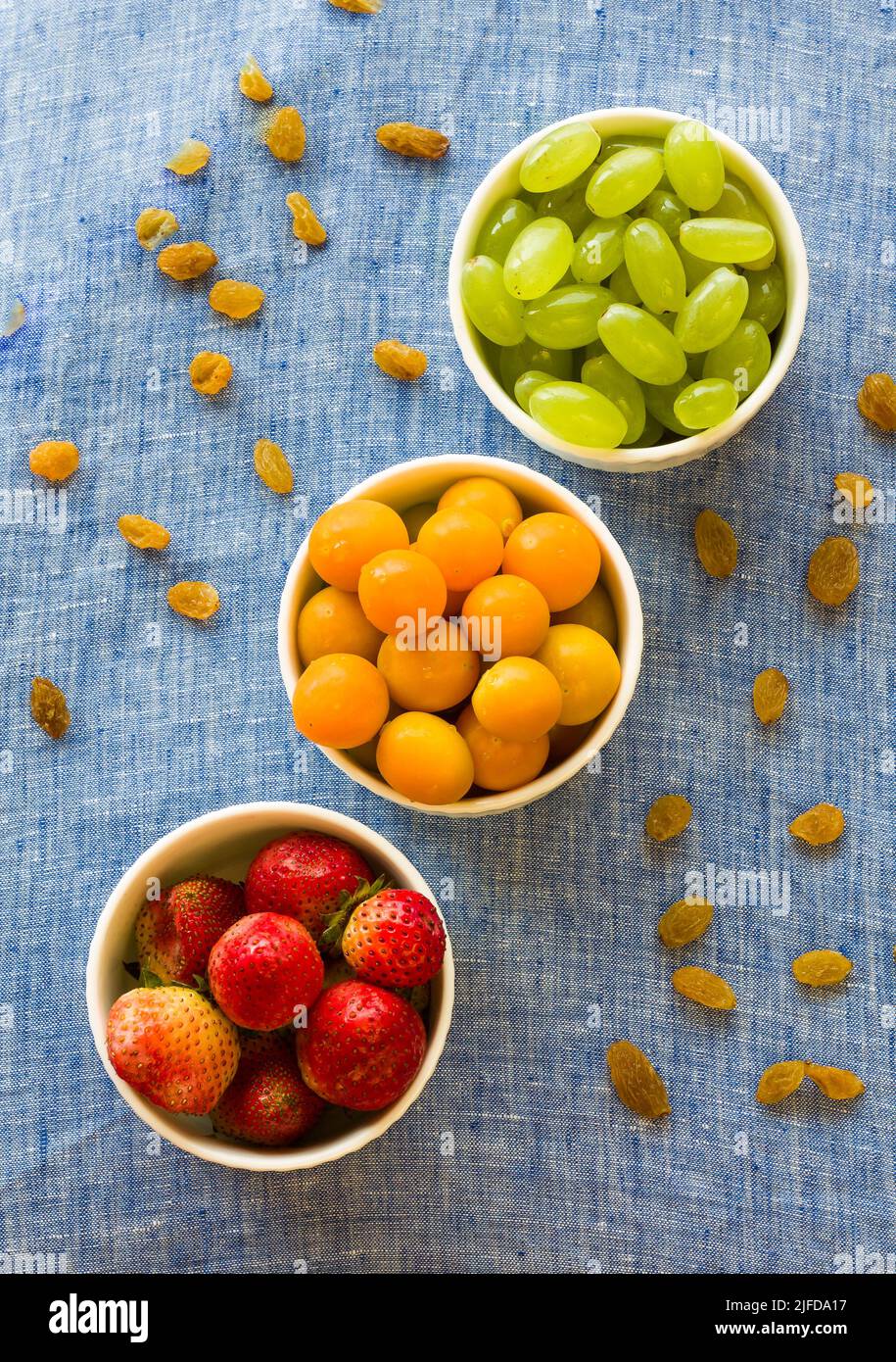 Bol à fruits avec assortiment de groseilles à maquereau, de raisins et de fraises frais et juteux, isolé sur fond rustique foncé. Concept rétroéclairé, fermé, végétalien Banque D'Images