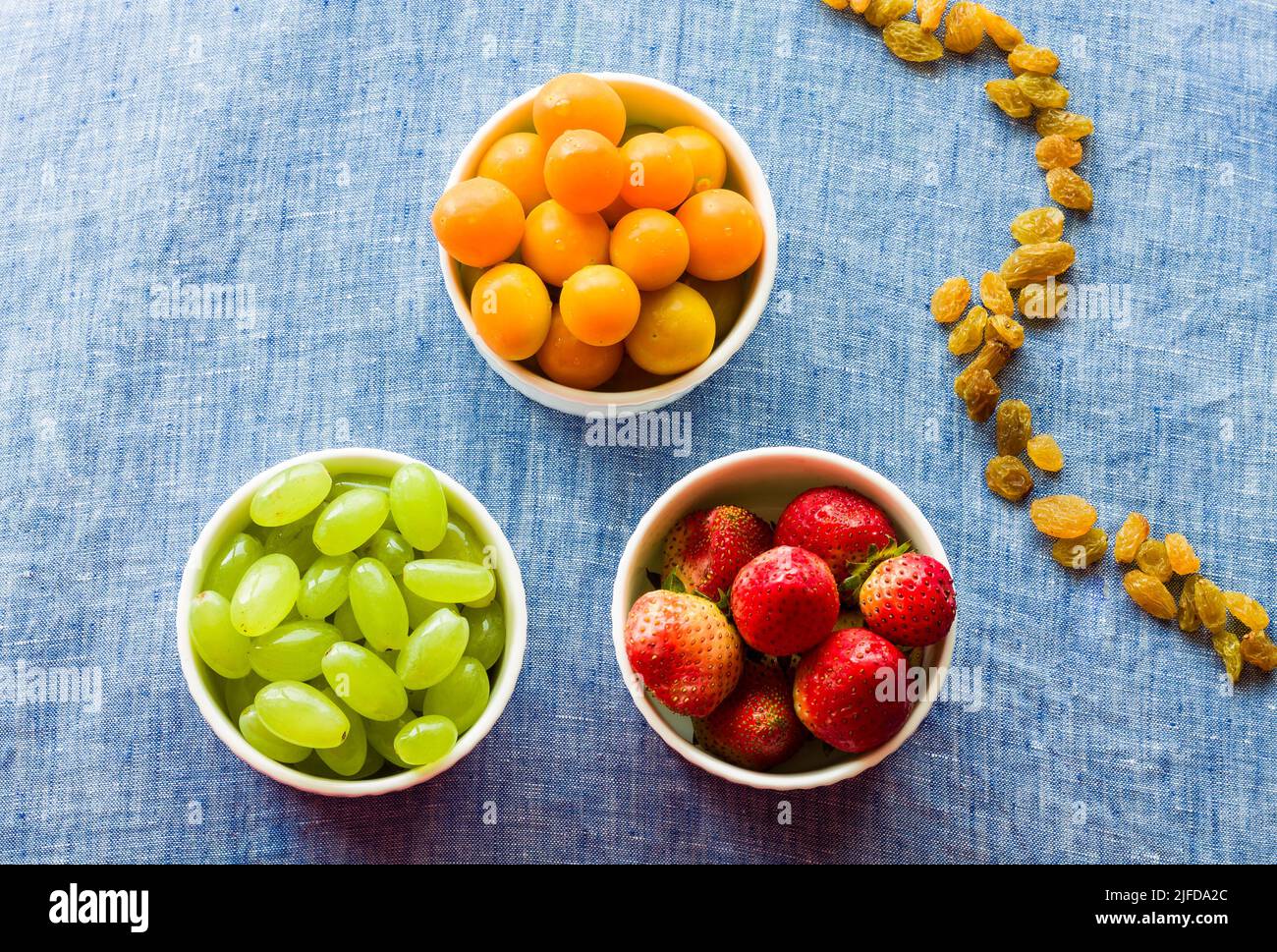 Bol à fruits avec assortiment de groseilles à maquereau, de raisins et de fraises frais et juteux, isolé sur fond rustique foncé. Concept rétroéclairé, fermé, végétalien Banque D'Images