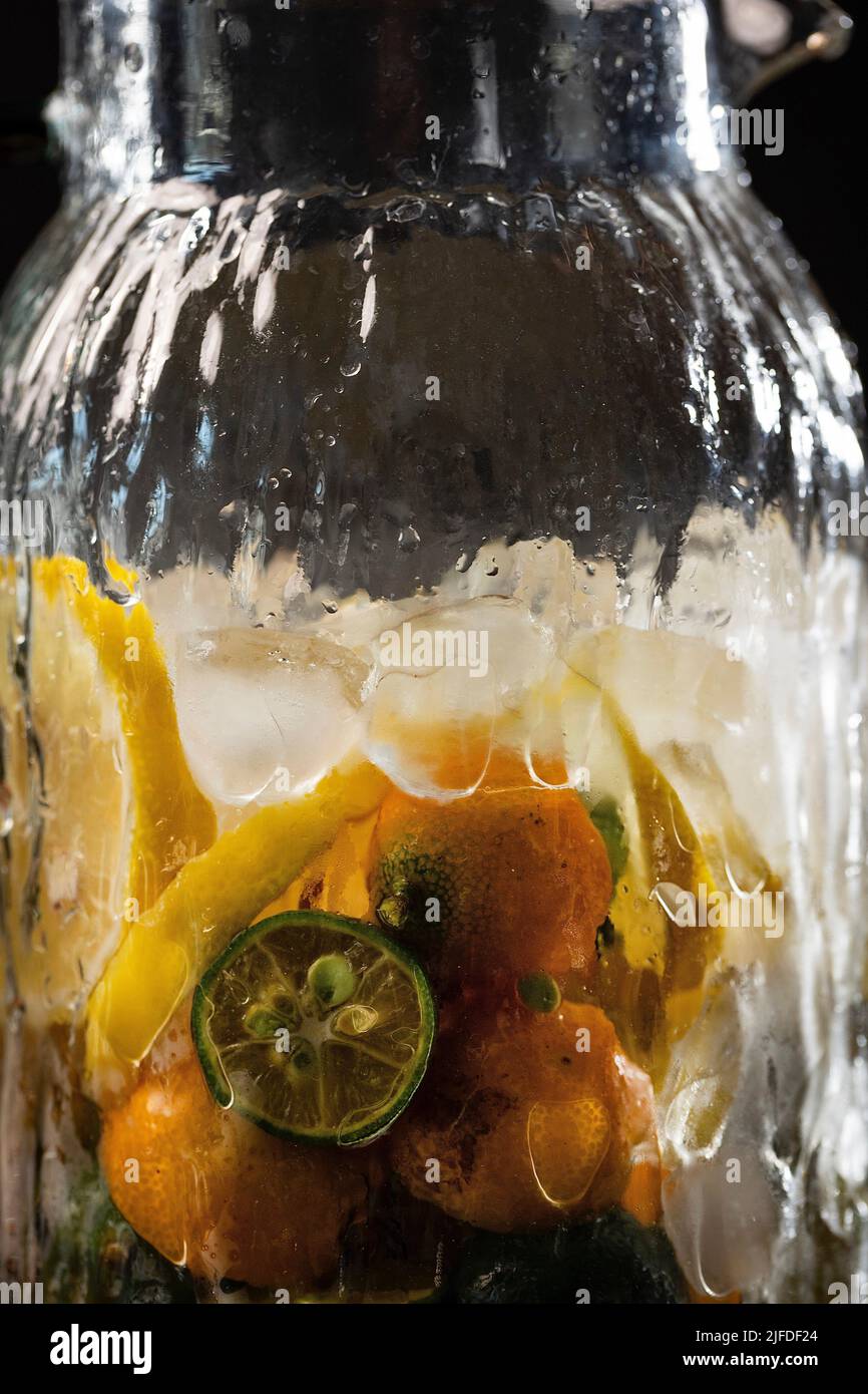 Agrumes réfrigérés dans des pots en verre, frais et fruité boisson froide processus de fabrication - photo de stock Banque D'Images