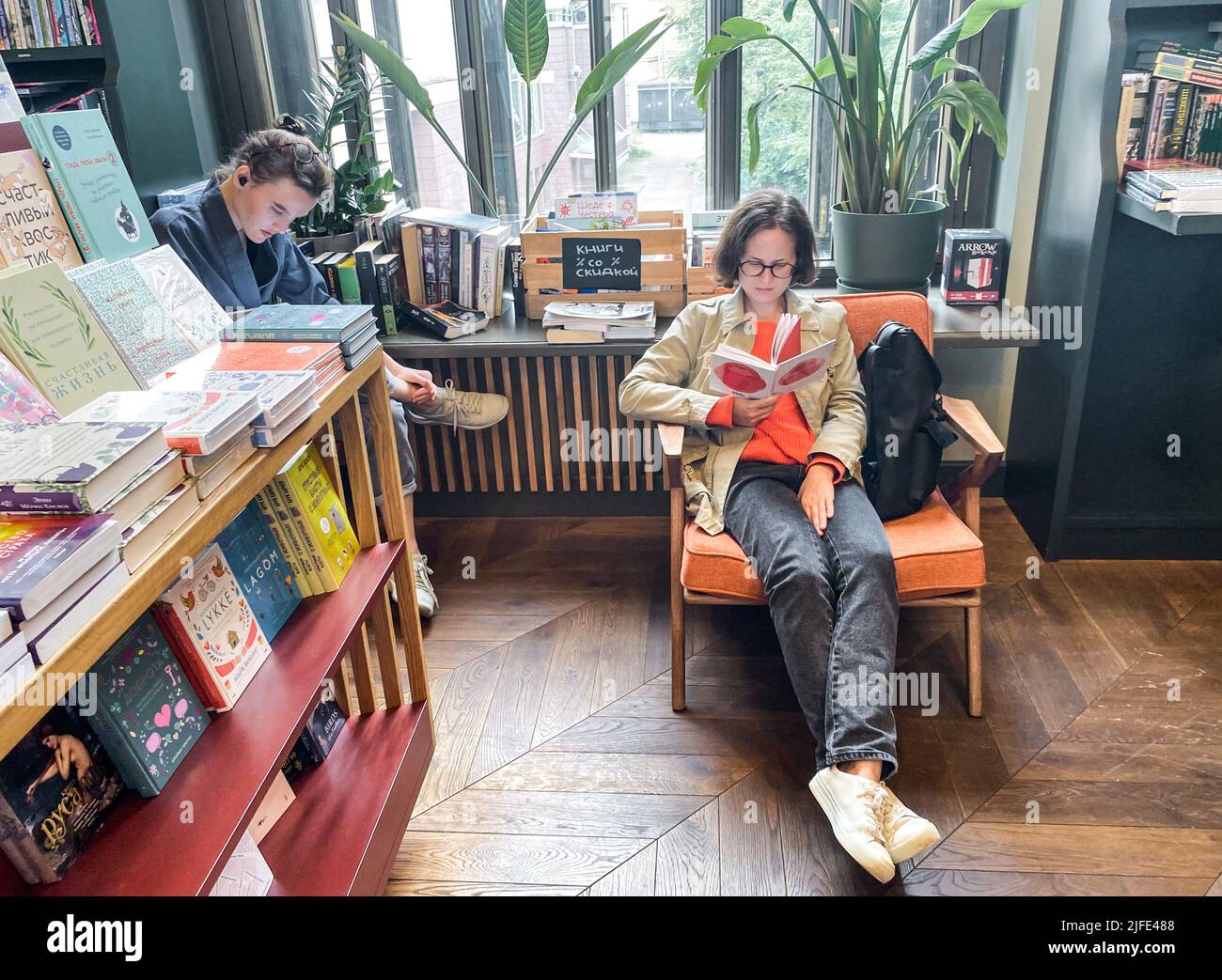 Saint-Pétersbourg, Russie, août 2021 : l'intérieur d'une librairie moderne et confortable dans un style rétro. Deux jeunes filles sont assises, lisant. Banque D'Images