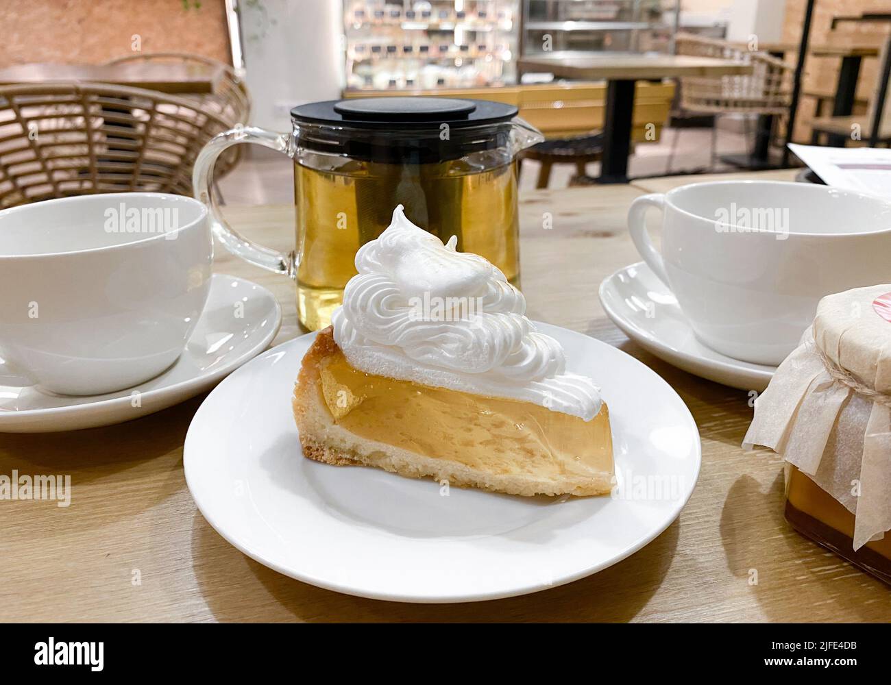 Gros plan d'un morceau de pâte à pain sablée avec gâteau à la gélatine transparente et crème à la meringue sur une table au café. Banque D'Images Gros plan d'un morceau de pâte à pain sablée avec gâteau à la gélatine transparente et crème à la meringue sur une table au café. Banque D'Images