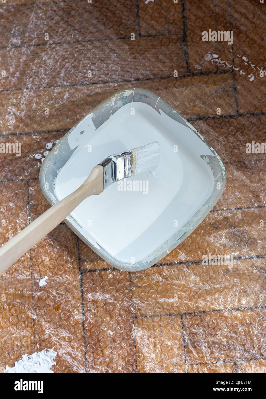 Brosse de radiateur trempée dans de la peinture blanche. Pinceau. Banque D'Images