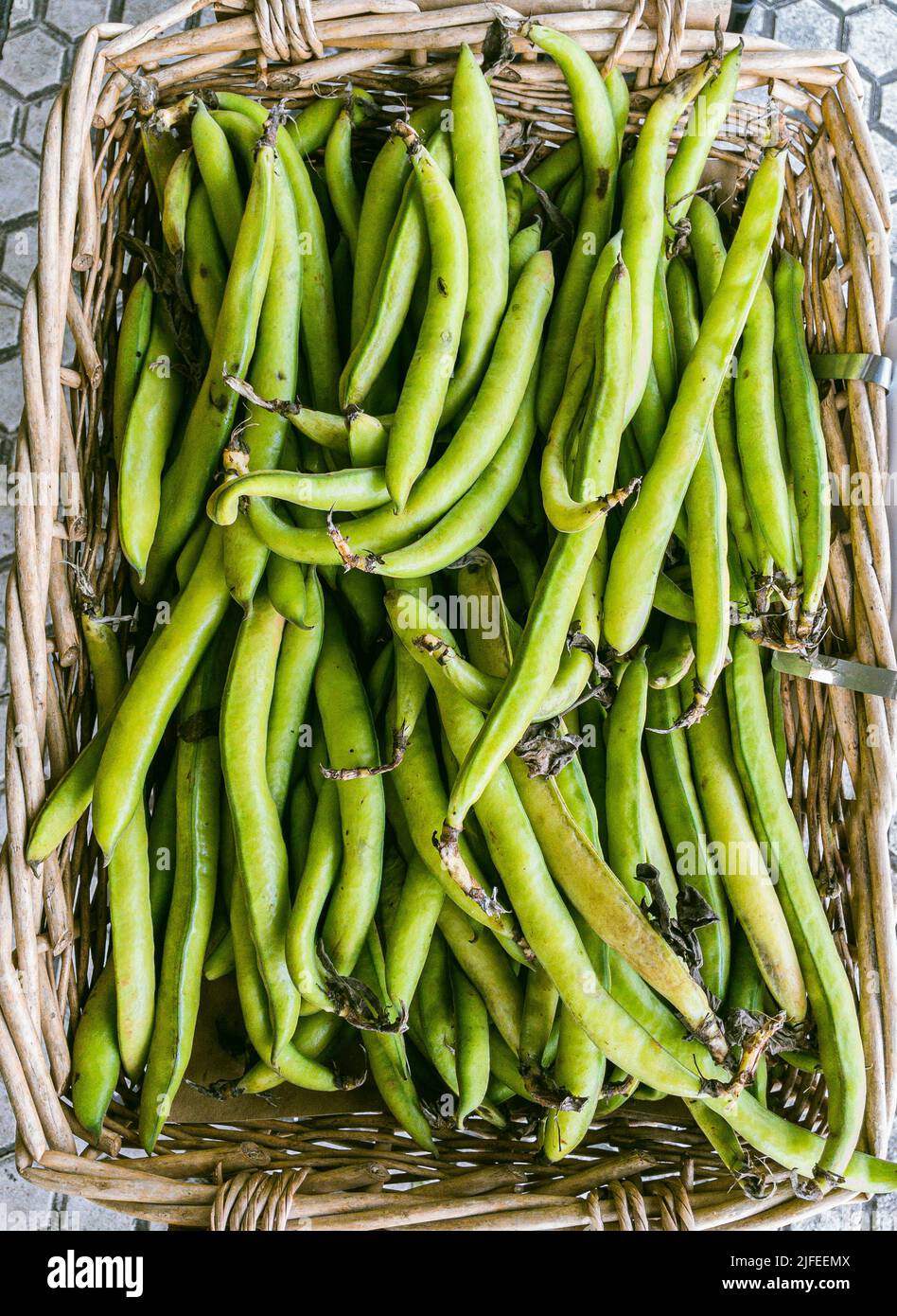 Larges gousses de haricots écologiques dans une boîte rustique. Banque D'Images