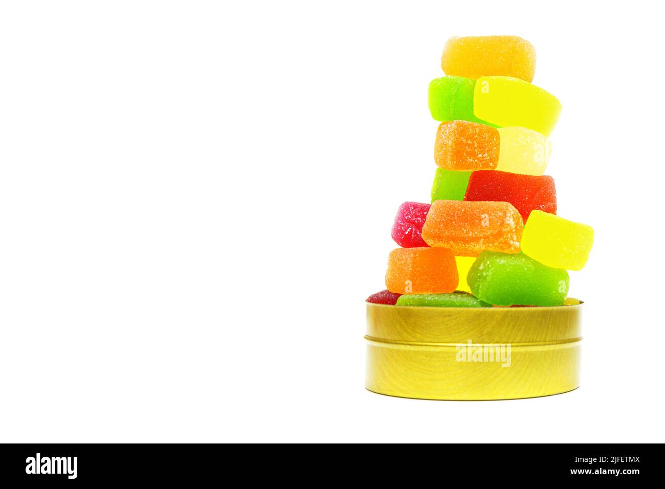 Grand groupe de bonbons en gelée de fruits empilés dans une boîte ronde isolée sur blanc. Banque D'Images