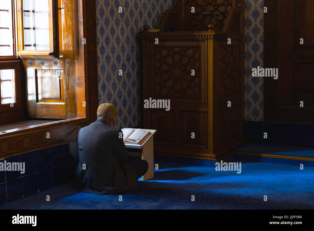 Un homme musulman aîné lisant le Saint Coran dans la mosquée. Photo d'arrière-plan de prière musulmane ou musulmane. Ankara Turquie - 5.16.2022 Banque D'Images