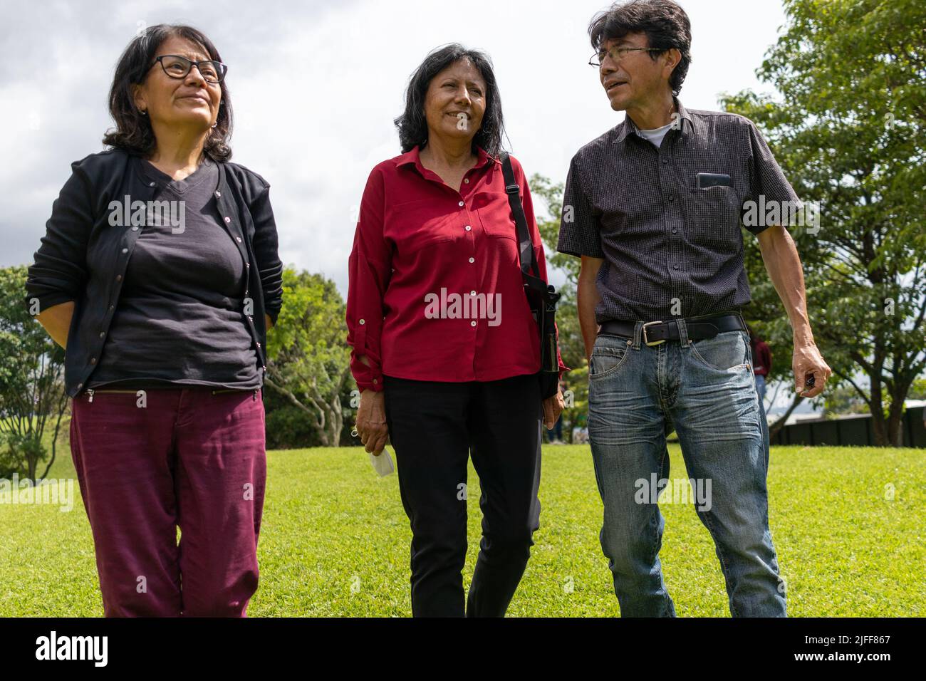 Groupe d'amis latins d'âge moyen marchant et parlant dans un parc, concept d'été Banque D'Images