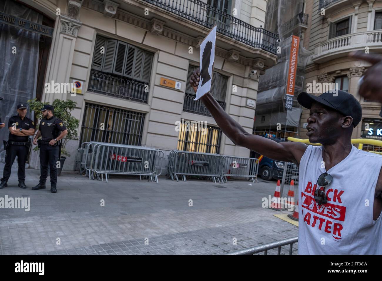 Un manifestant a la silhouette symbolique d'un présumé migrant décédé à Melilla devant les agents de la police nationale au poste de police de Vía Laietana. Des centaines de personnes ont manifesté dans le centre de Barcelone et ont finalement formé un autel sur la place Idrissa Diallo à l'occasion du massacre de Melilla où plus d'une trentaine de migrants africains sont morts en raison de la répression de la police marocaine après avoir essayé de sauter la barrière espagnole. Banque D'Images