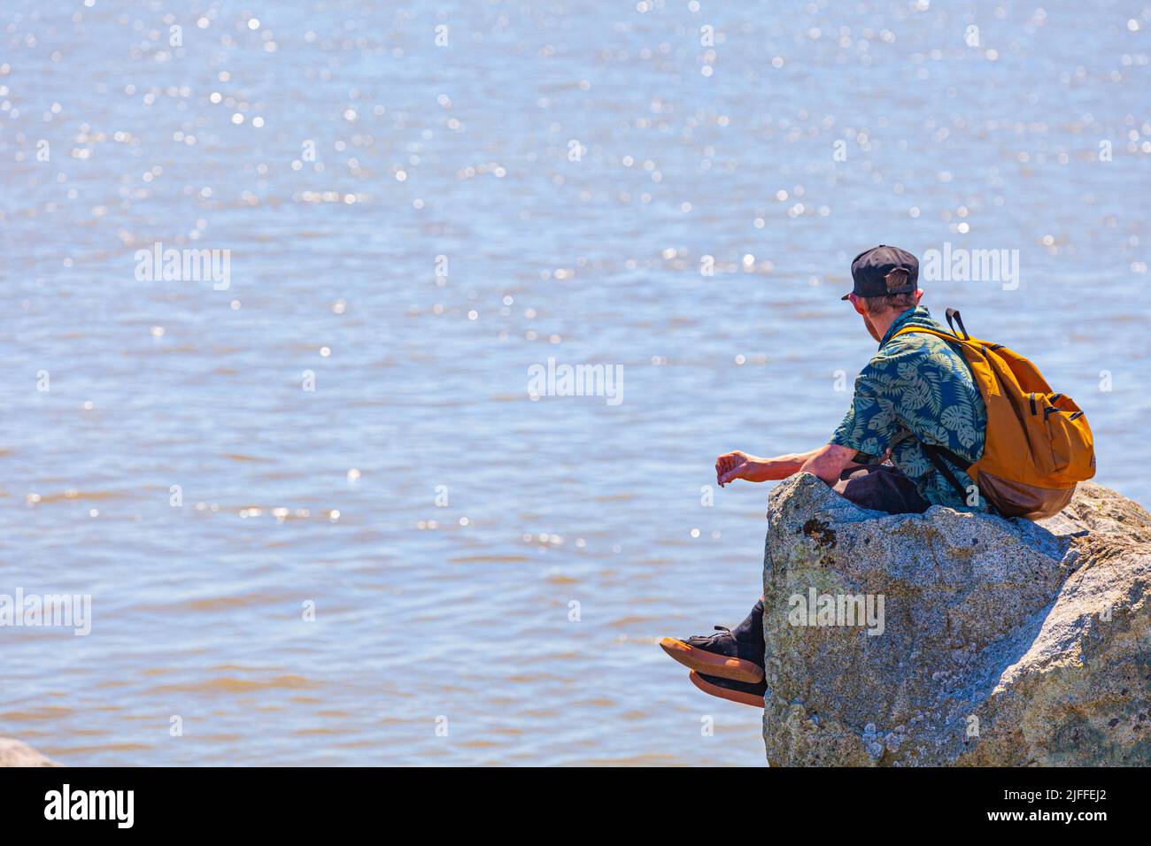 Homme avec un chapeau qui regarde sur le fleuve Fraser à Steveston, en Colombie-Britannique, à l'occasion de la fête du Canada 2022 Banque D'Images