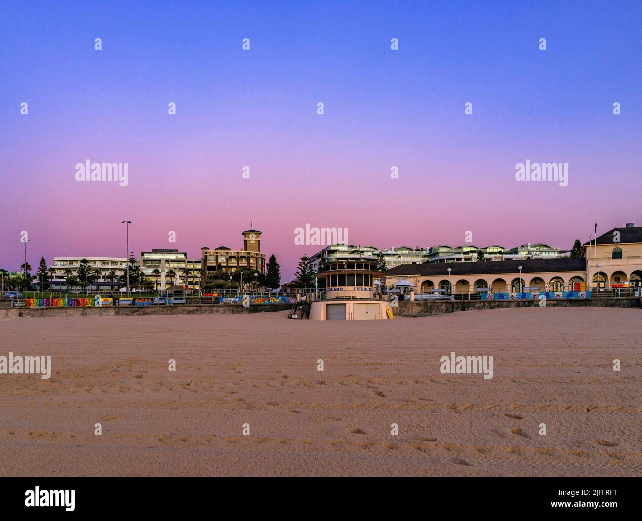 Magnifique ciel aux couleurs pastel tandis que le soleil se couche sur la célèbre plage de Bondi, en regardant de nouveau vers Campbell Parade avec la tour de sauvetage de Bondi Banque D'Images