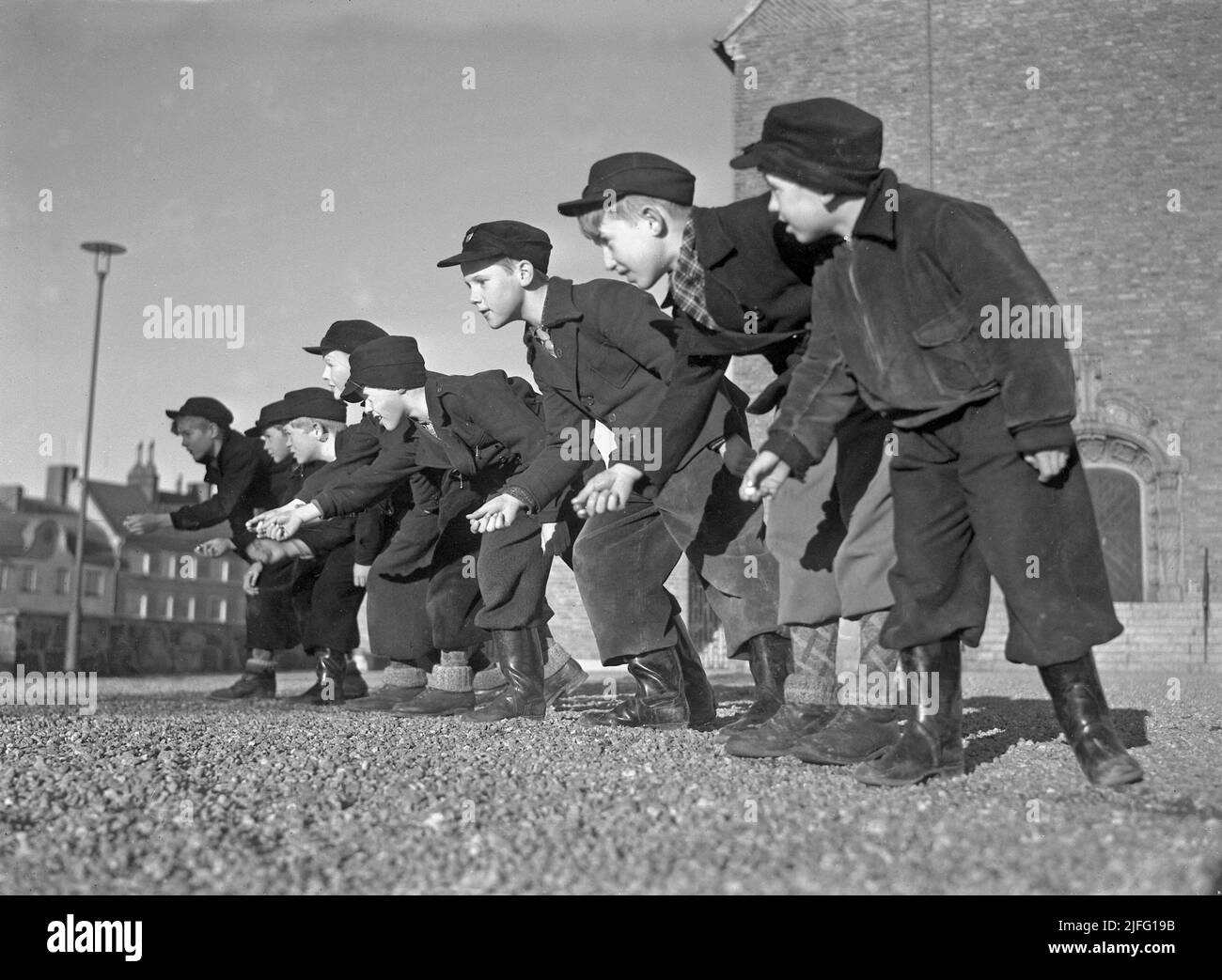 1940s été. Garçons jouant à l'extérieur des billes. Un jeu à l'ancienne où le but est de frapper la pyramide des billes avec juste un marbre. Si vous frappez, vous avez gagné les billes dans la pyramide, sinon le marbre a été perdu. Il y avait aussi des variantes du jeu. Suède avril 1940 Kristoffersson réf. 111-3 Banque D'Images