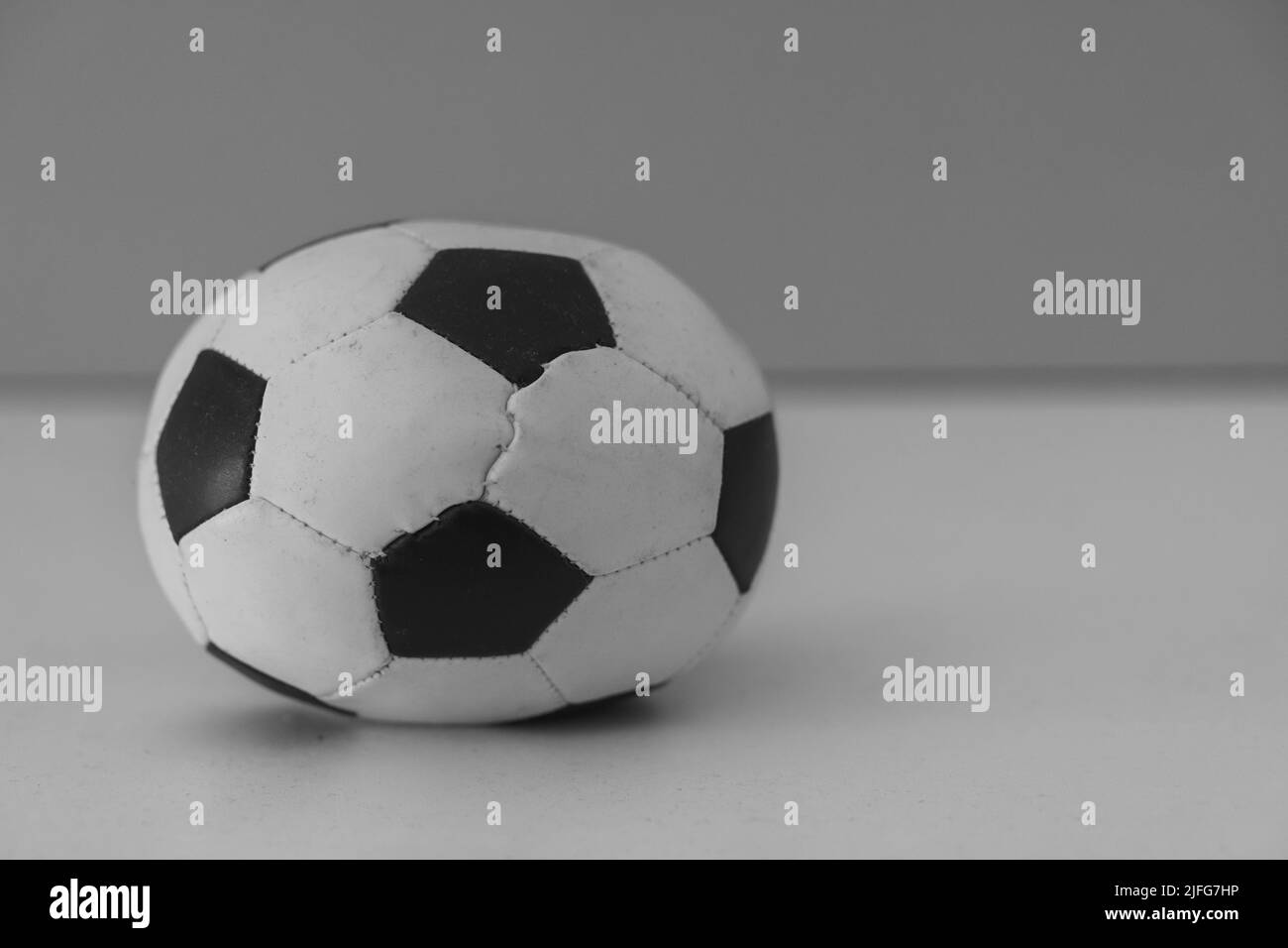 Gros plan d'un vieux ballon de football noir et blanc sur un arrière-plan flou Banque D'Images