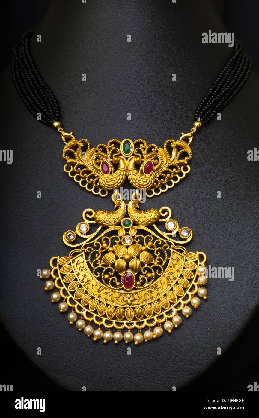 Collier de Temple ( Mangalsutra) avec perles noires et pierres rouges, vertes, diamant sur fond noir Banque D'Images