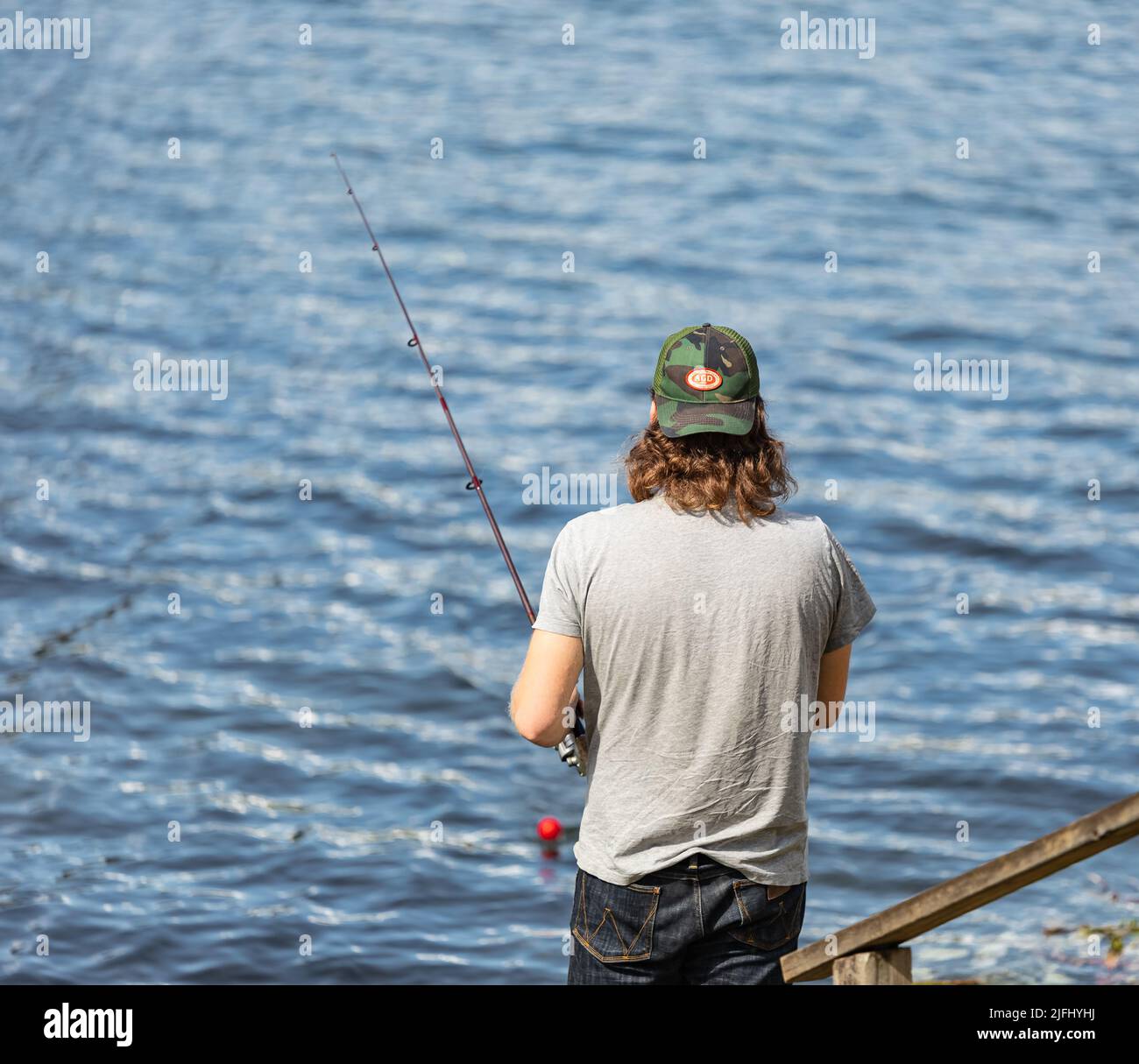 Pêche à la mouche dans un lac Pitt en Colombie-Britannique, Canada. Pêcheur utilisant la pêche à la mouche dans la rivière en été. Photo de voyage, mise au point sélective, copie Banque D'Images